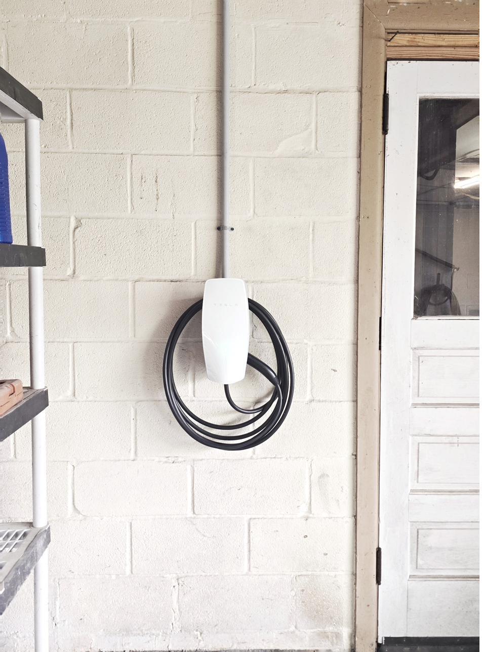 Finished Tesla Universal Wall Connector installed on block wall in Bellefonte garage