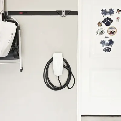 Finished Tesla Wall Connector installed in the Bellefonte garage with the cable coiled · Steel Fox EV & Electric, Central PA