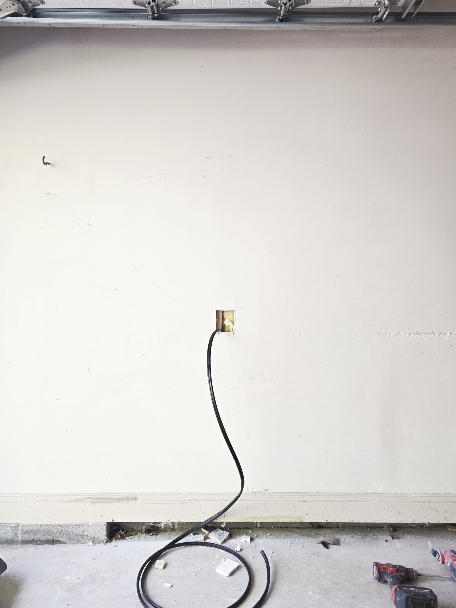 Tesla Wall Connector install in progress — cable routed through wall