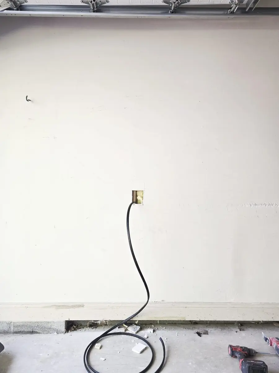 Tesla Wall Connector install in progress · cable routed through wall