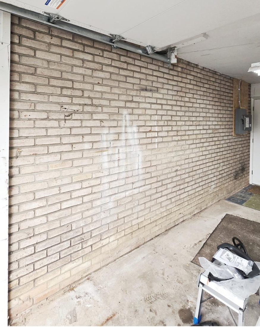 Garage brick wall before EV charger install, sub-panel visible, State College PA