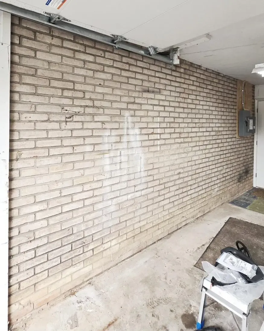 Garage brick wall before EV charger install, sub-panel visible, State College PA