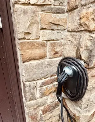 ChargePoint charger installed on a stone exterior wall · Steel Fox EV & Electric, Central PA